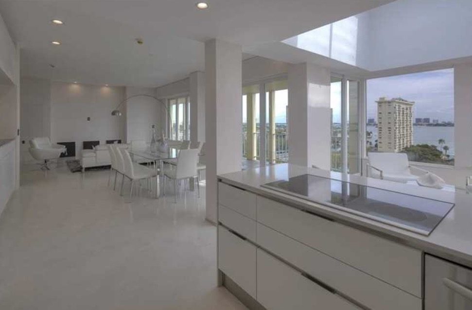 Seamless poured resin floor running through an open-plan penthouse kitchen